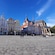 Colorful buildings lining a cobblestone public square with pedestrians